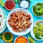 salsa chicken in a bowl surrounded by veggies.