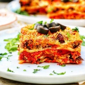 slice of mexican lasagna topped with black olives.