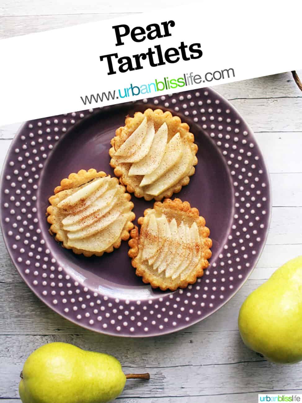 three baked pear tartlets on a purple plate with text overlay.