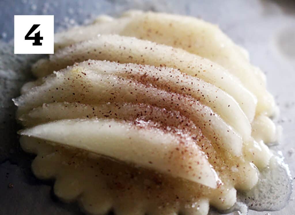 close up of sliced pears with cinnamon on pie dough cut out.