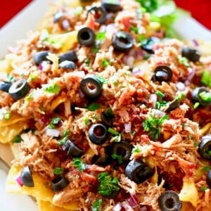 pulled pork nachos topped with black olives.
