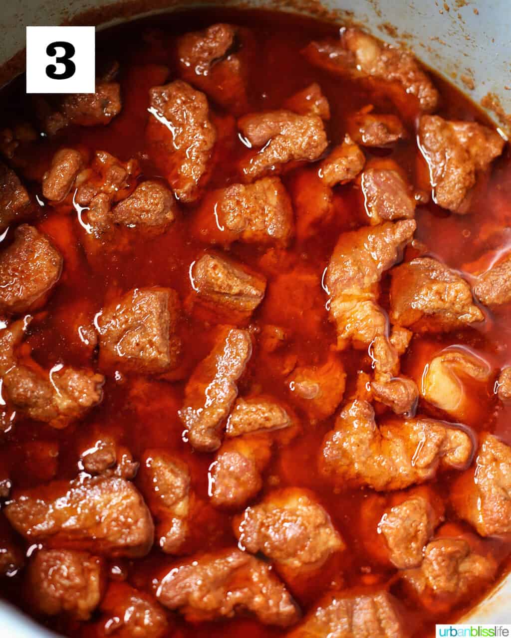 pork shoulder pieces in juices in slow cooker.