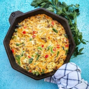 sausage frittata with spring vegetables in cast iron skillet.