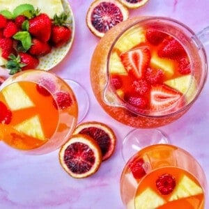 tropical rosé sangria in three glasses with blood orange slices.