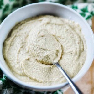 Vegan Cashew Cheese in a bowl with a spoon and green patterned napkin.