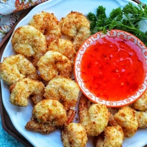 air fryer coconut shrimp with red dipping sauce.