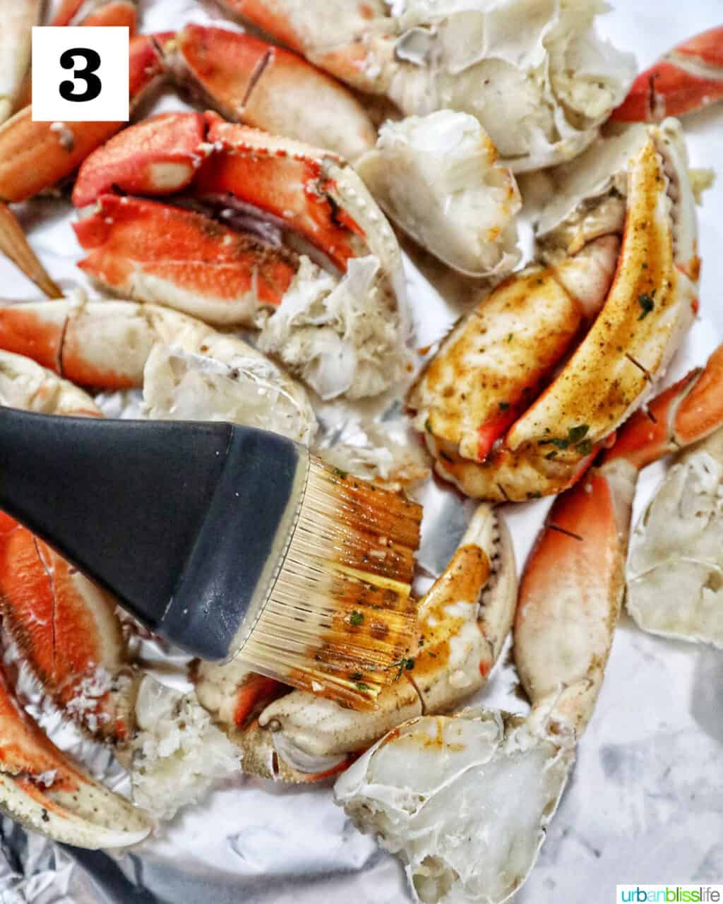a basting brush brushing seasoned sauce onto crab legs.