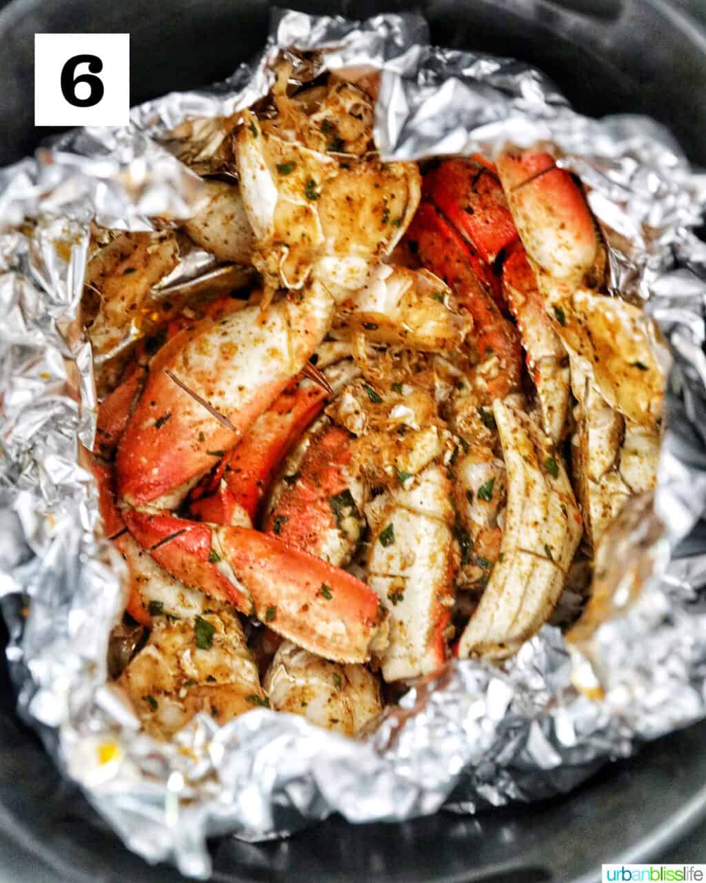 seasoned crab legs wrapped in aluminum foil in the air fryer.
