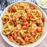 cajun shrimp pasta with herbs in a white bowl.