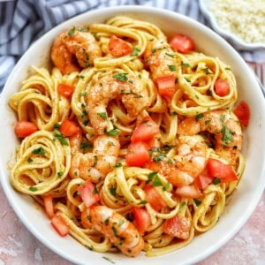 cajun shrimp pasta with herbs in a white bowl.