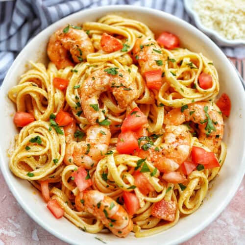 cajun shrimp pasta with herbs in a white bowl.