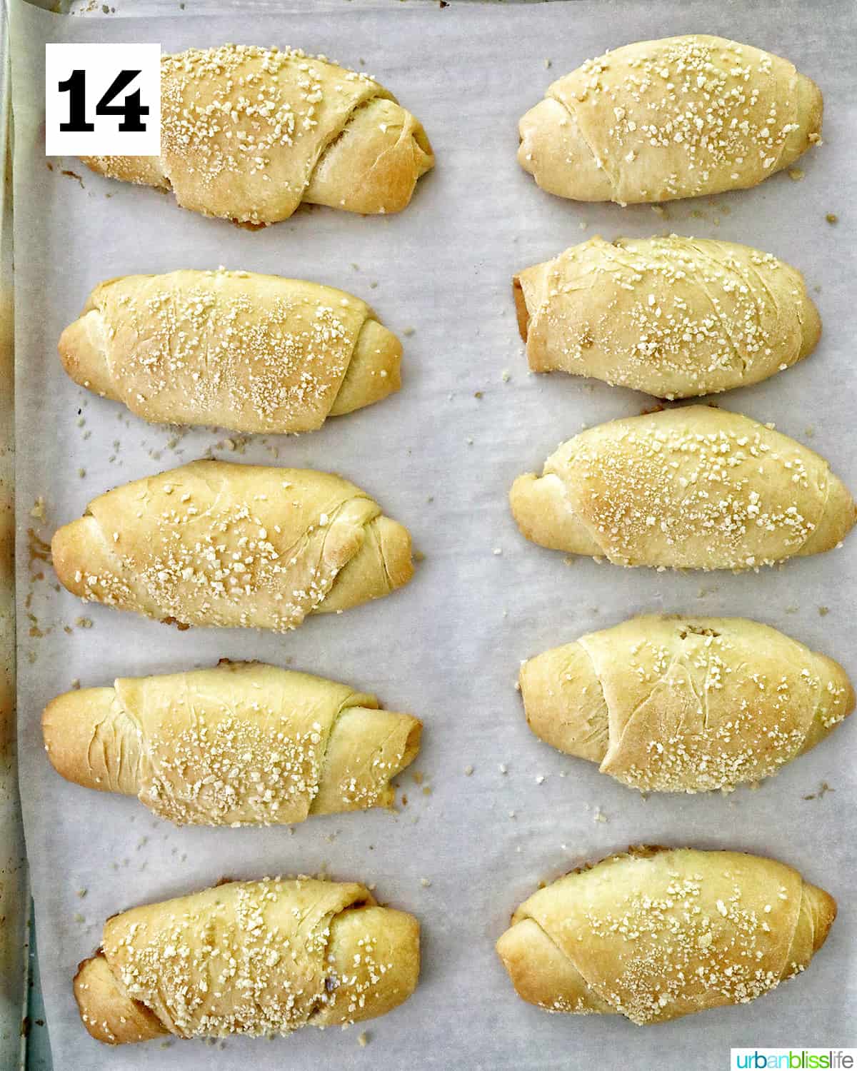 baked Filipino Spanish bread on a parchment paper-lined baking sheet.