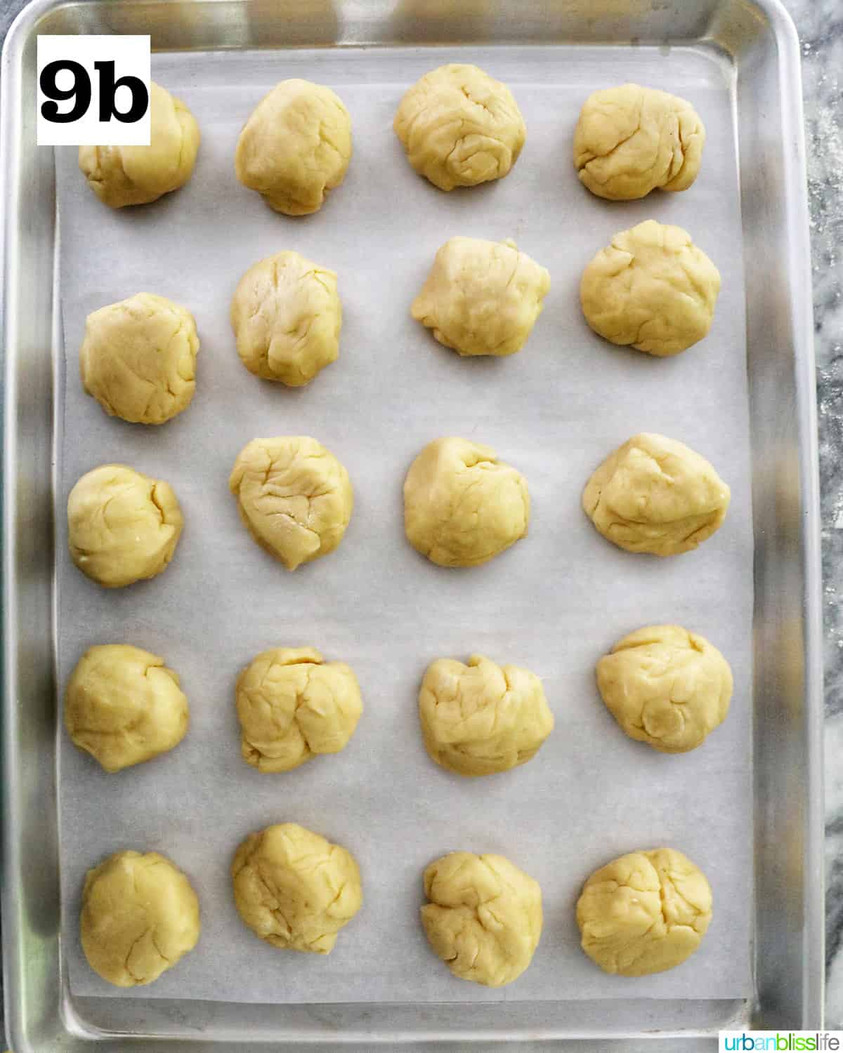 20 dough balls on a parchment paper-lined baking sheet to make Spanish bread.