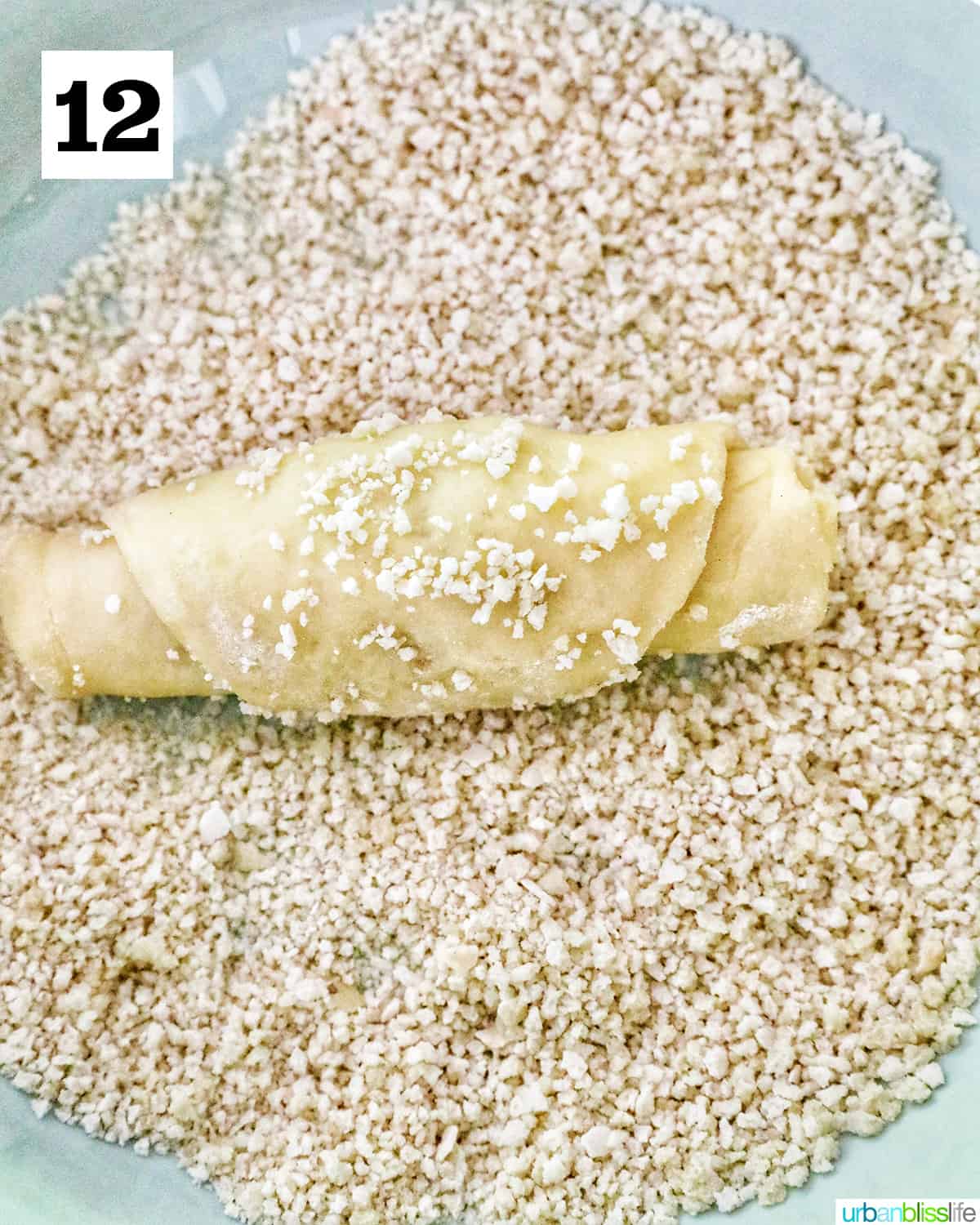 rolling a spanish bread dough in breadcrumbs.