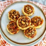 several mini pecan pies on a plate.