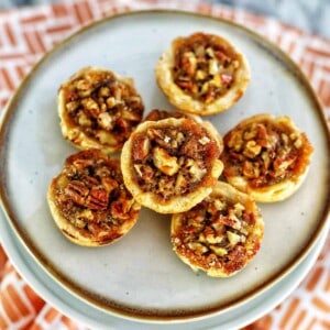 several mini pecan pies on a plate.