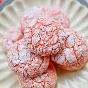 strawberry crinkle cookies stacked in a white plate.