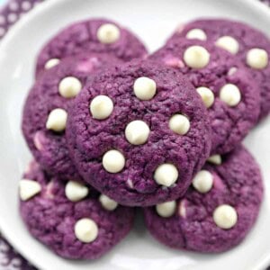 white chocolate chip ube cookies on a plate.