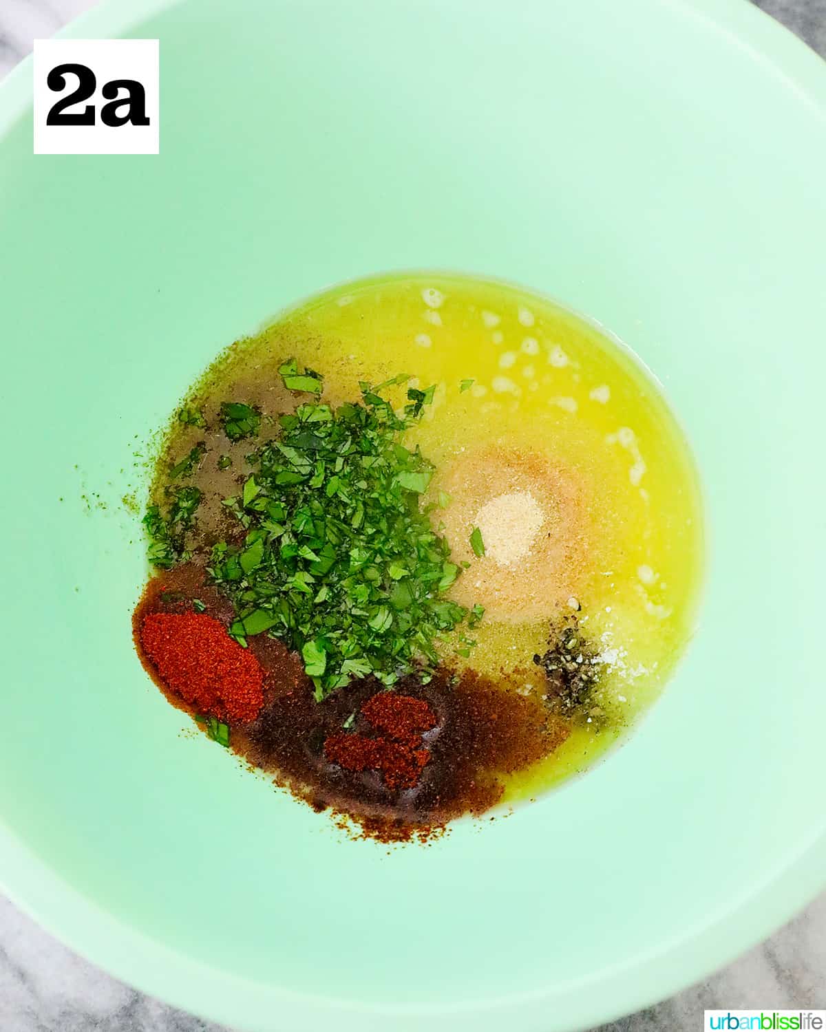 green bowl rilled with sectioned ingredients to make seasoned sauce for air fryer corn ribs.