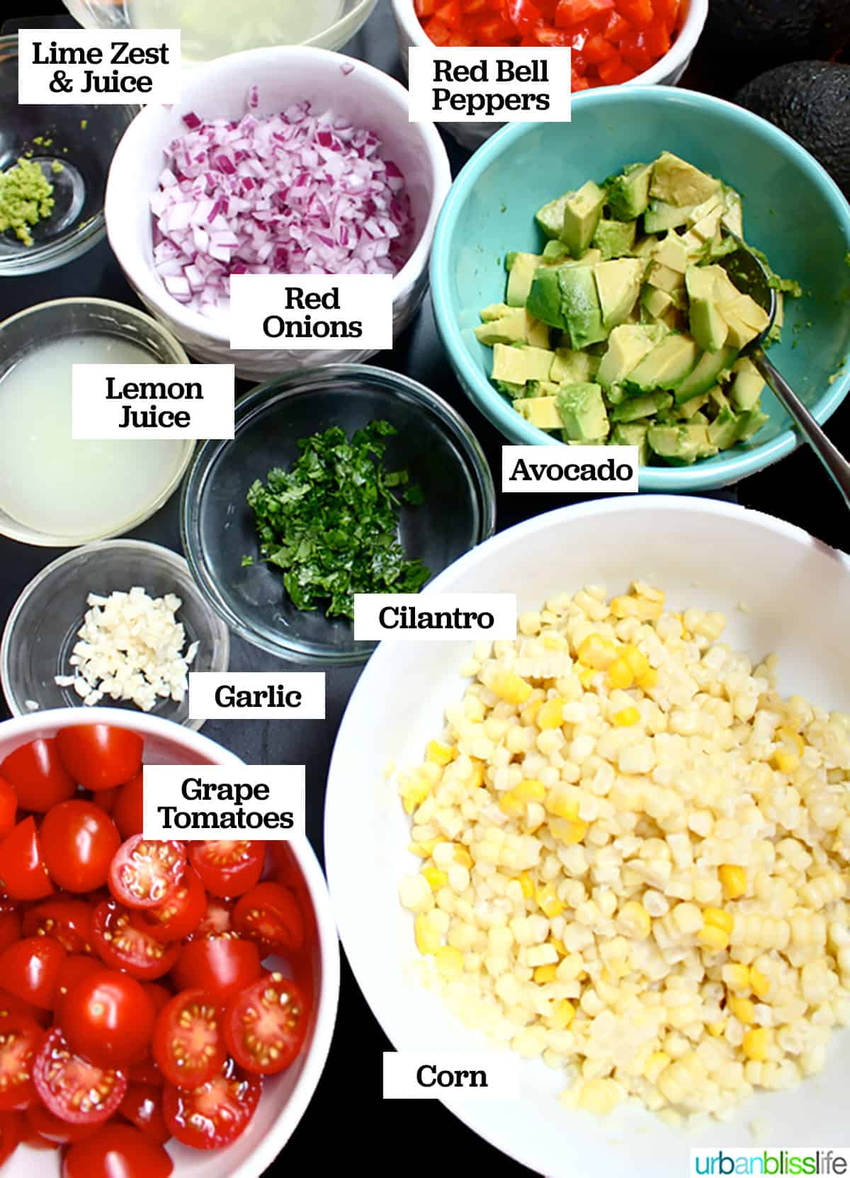 ingredients for avocado corn salad: avocado, corn, grape tomatoes, red onion, garlic, lime juice, lemon juice.