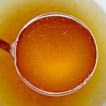homemade turkey stock in a ladle.