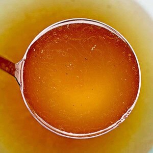 homemade turkey stock in a ladle.