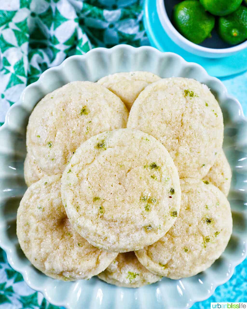 key lime cookies on a plate with a side bowl of key limes.
