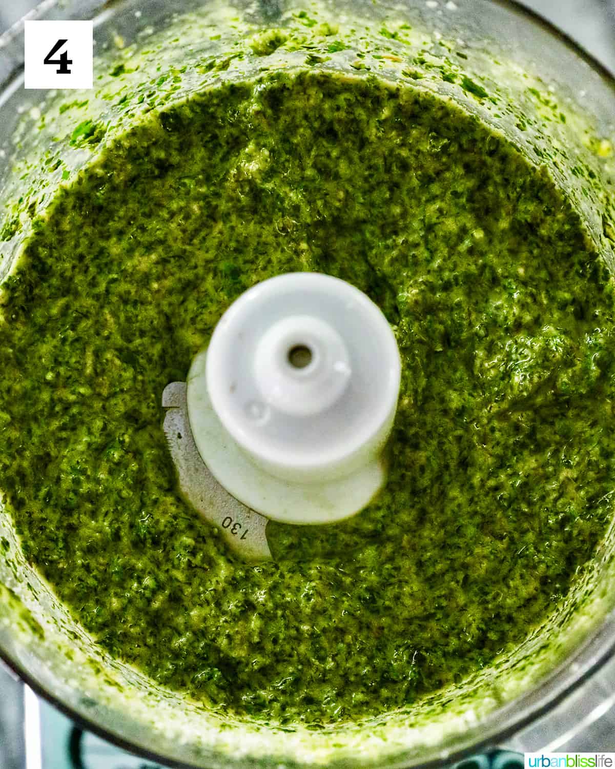 fully blended bright green mint pesto finished processing in a food processor.