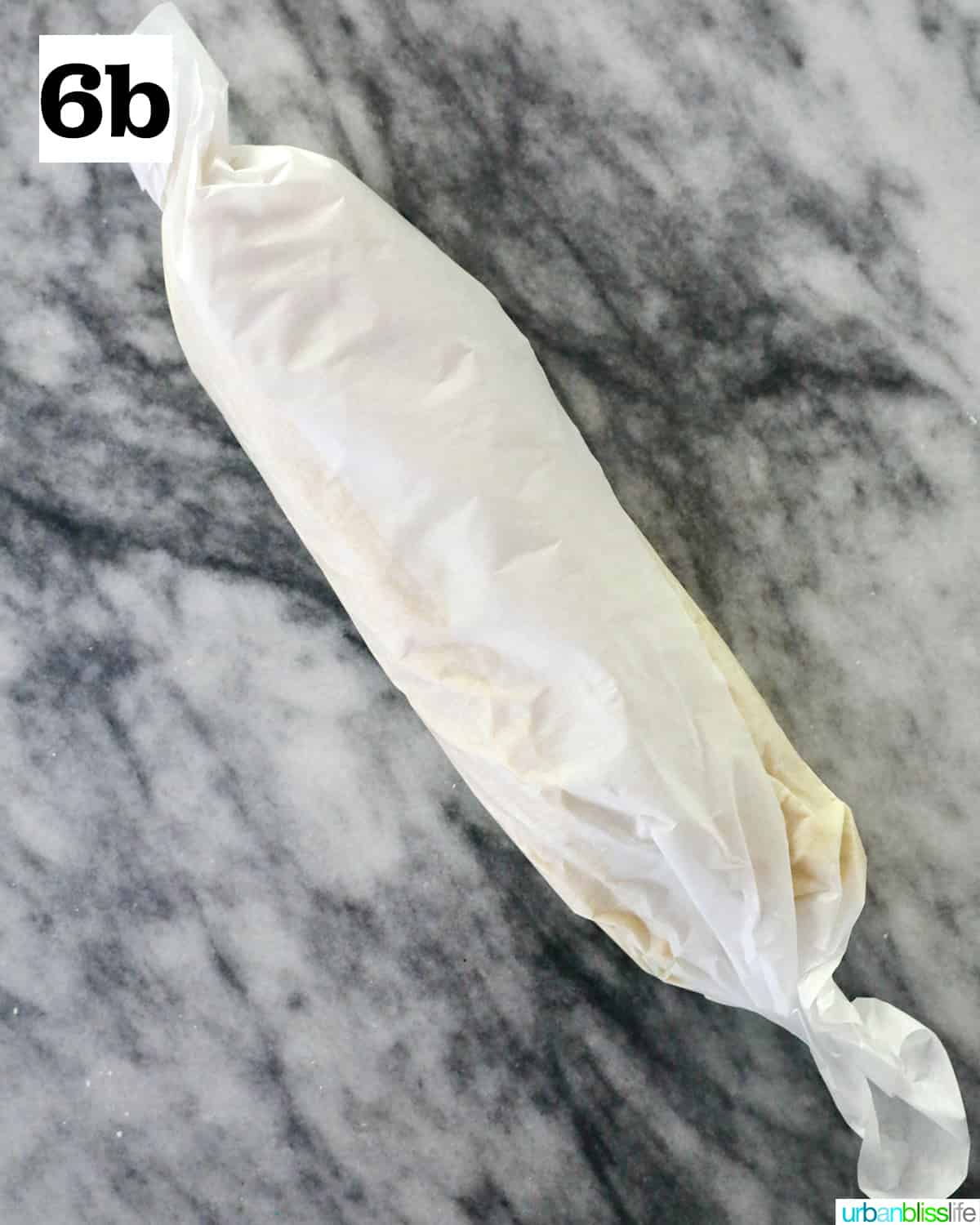 parchment paper rolled with key lime cookie batter on marble countertop