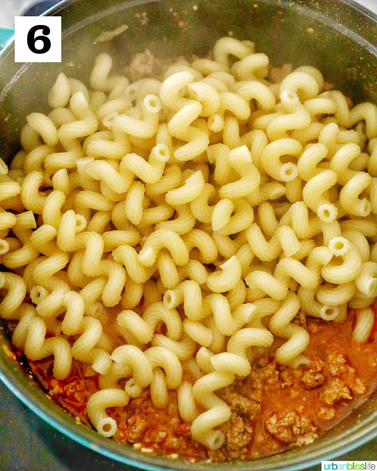 adding pasta to sauce.