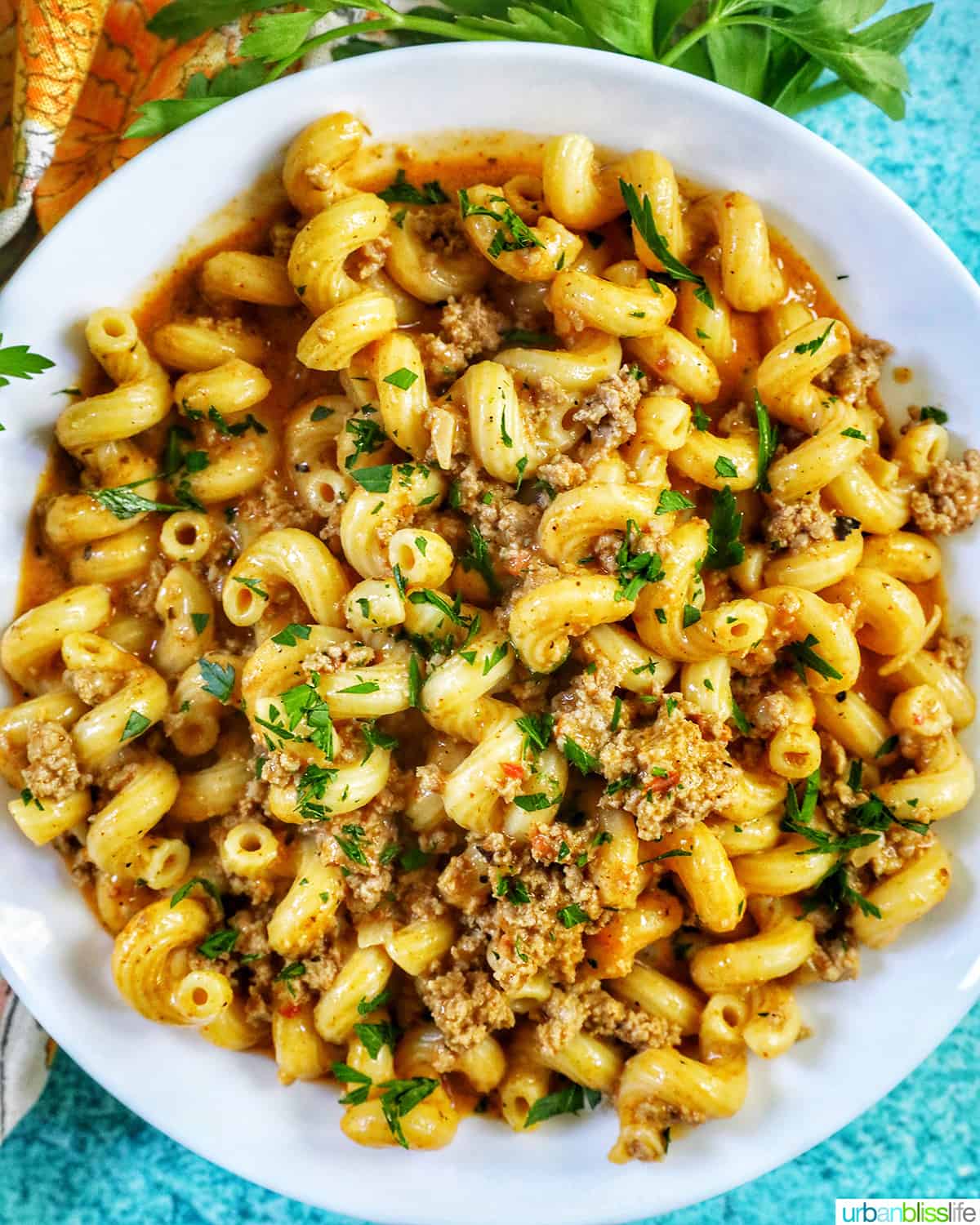 bowl of dairy free one pot cheeseburger pasta with ground turkey and chopped parsley.