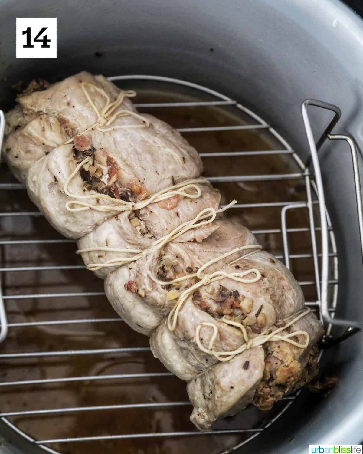 cooked stuffed pork loin wrapped in kitchen string on a rack in the instant pot.