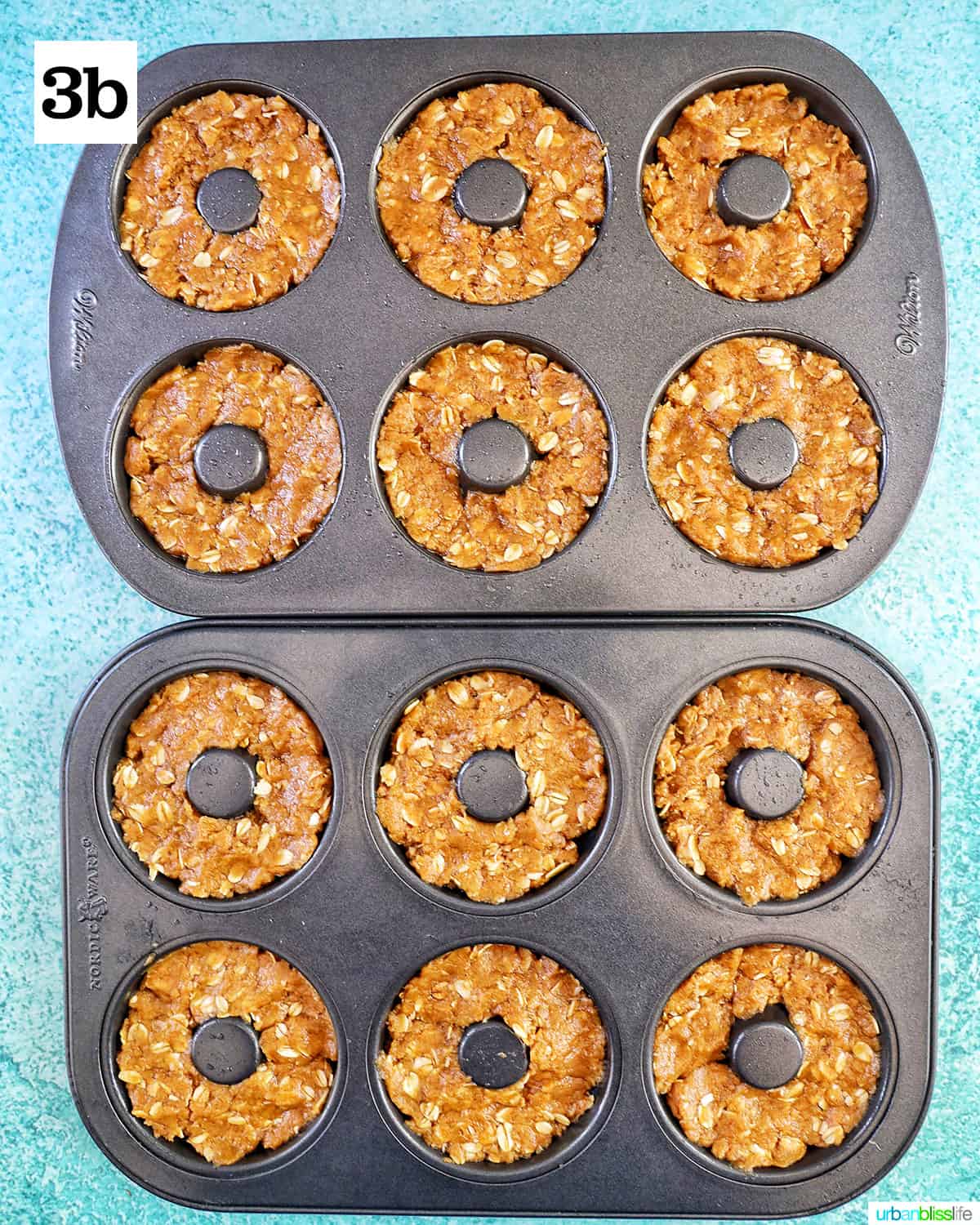 two donut pans with dog donut batter on a bright blue table.
