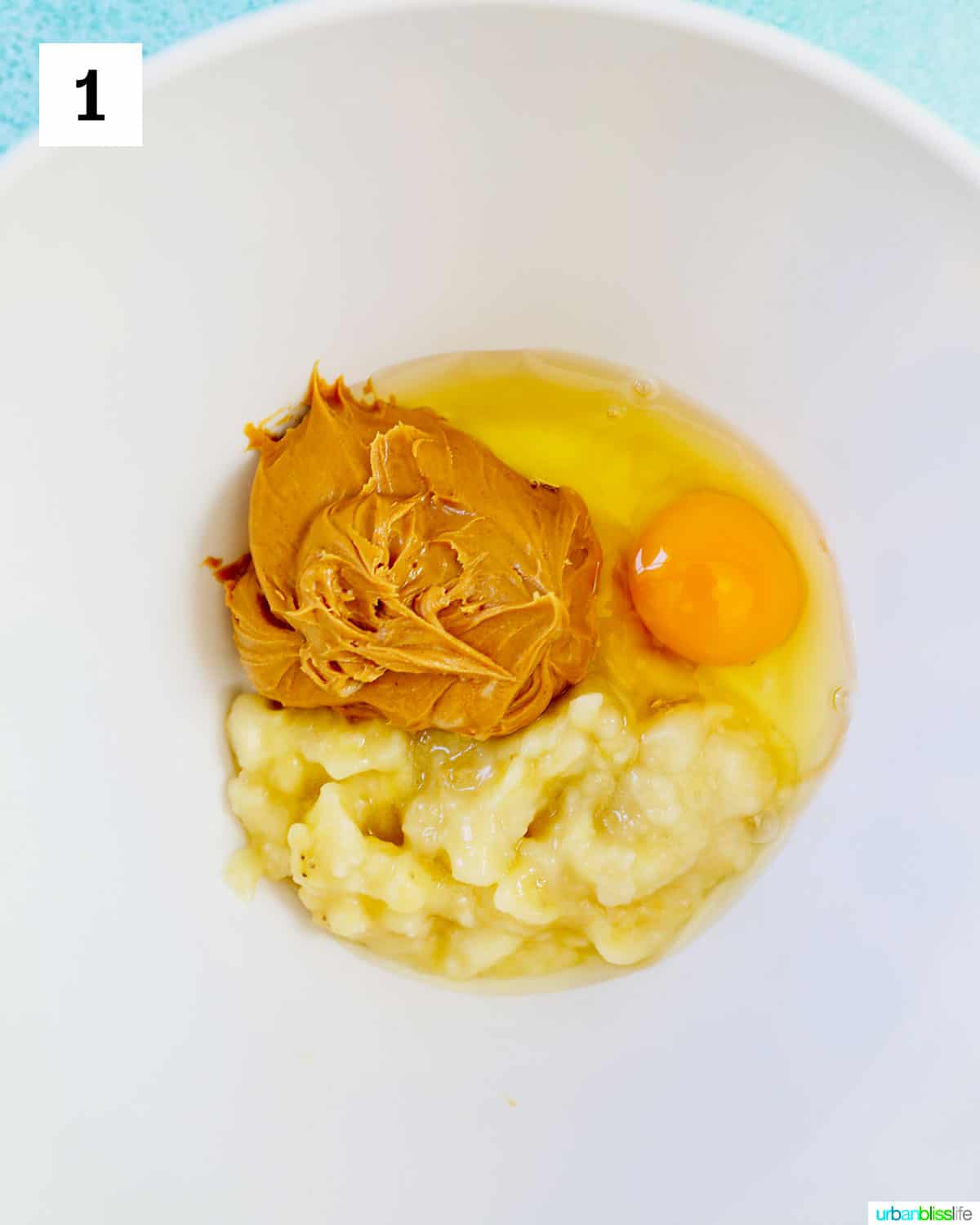 white bowl with peanut butter, eggs, bananas.