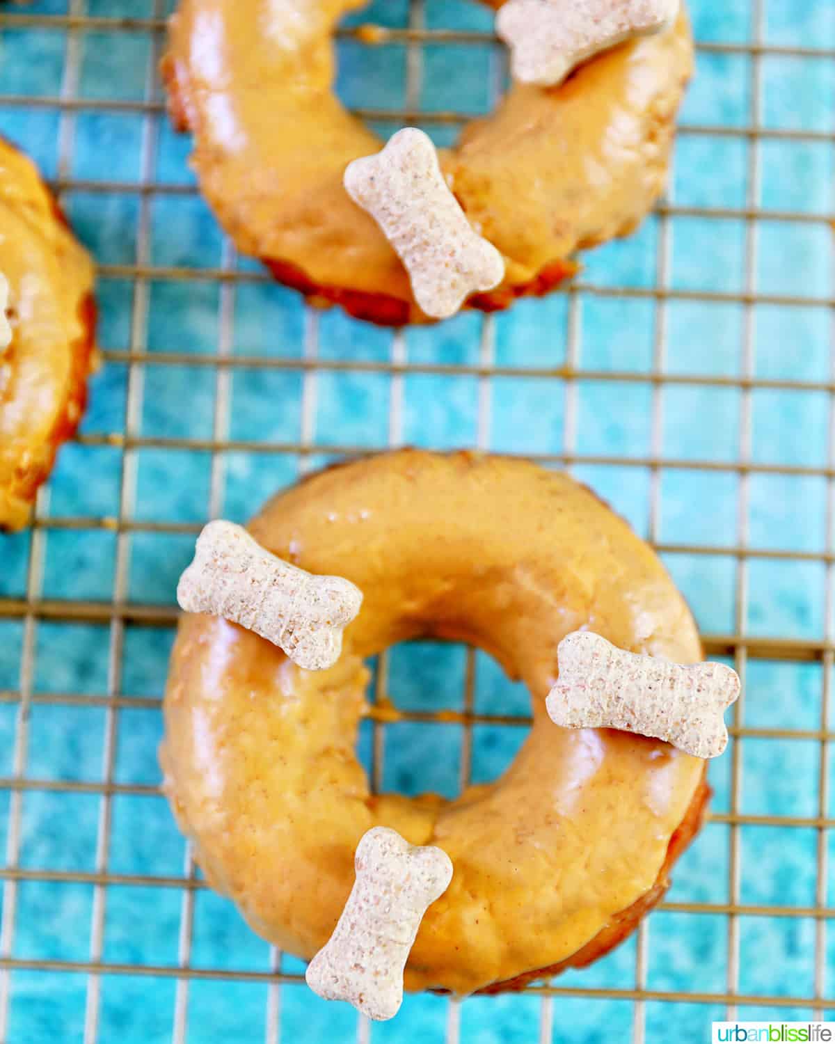 three dog donuts with dog biscuits on a cooling rack.