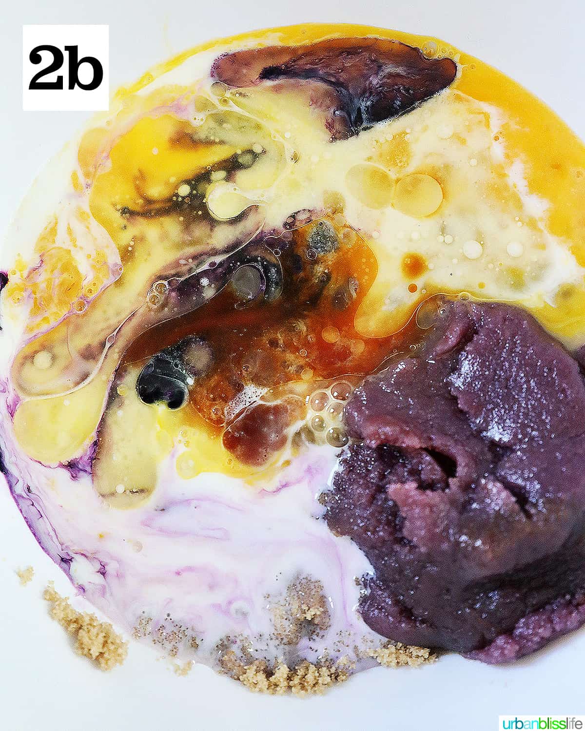 ube jam, eggs, vanilla, brown sugar in a white bowl to make ube donuts batter.
