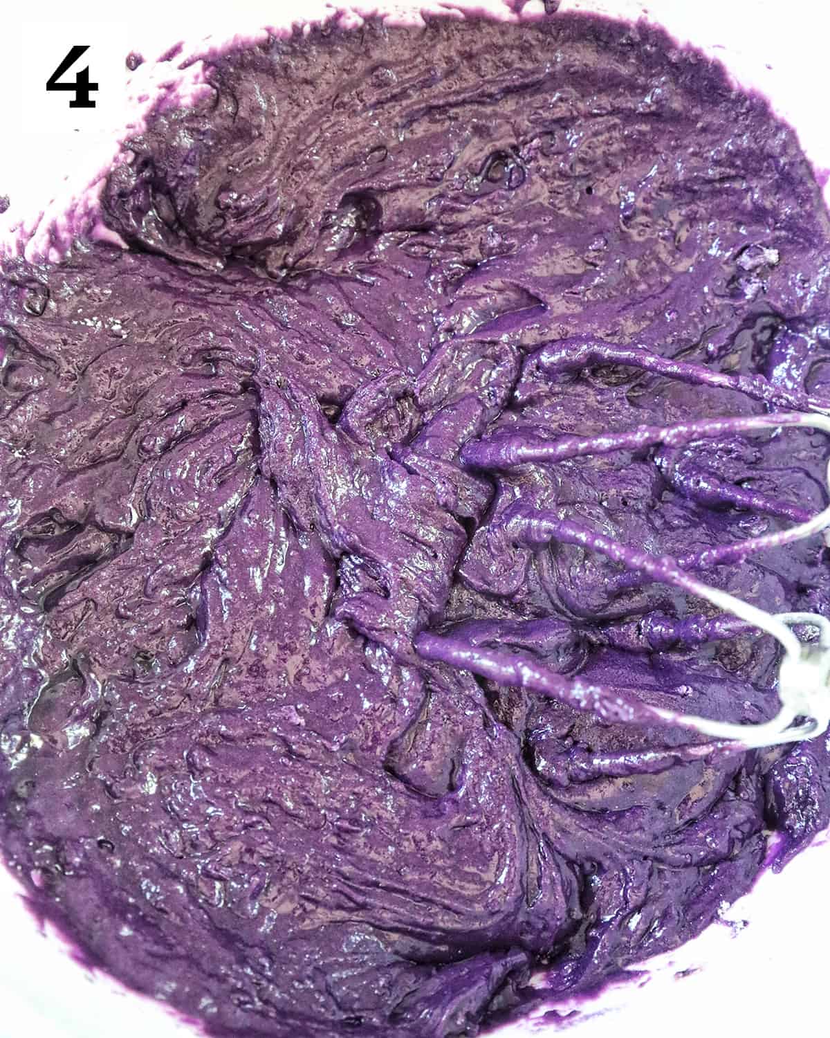 whisks in a bowl of purple ube donut batter.