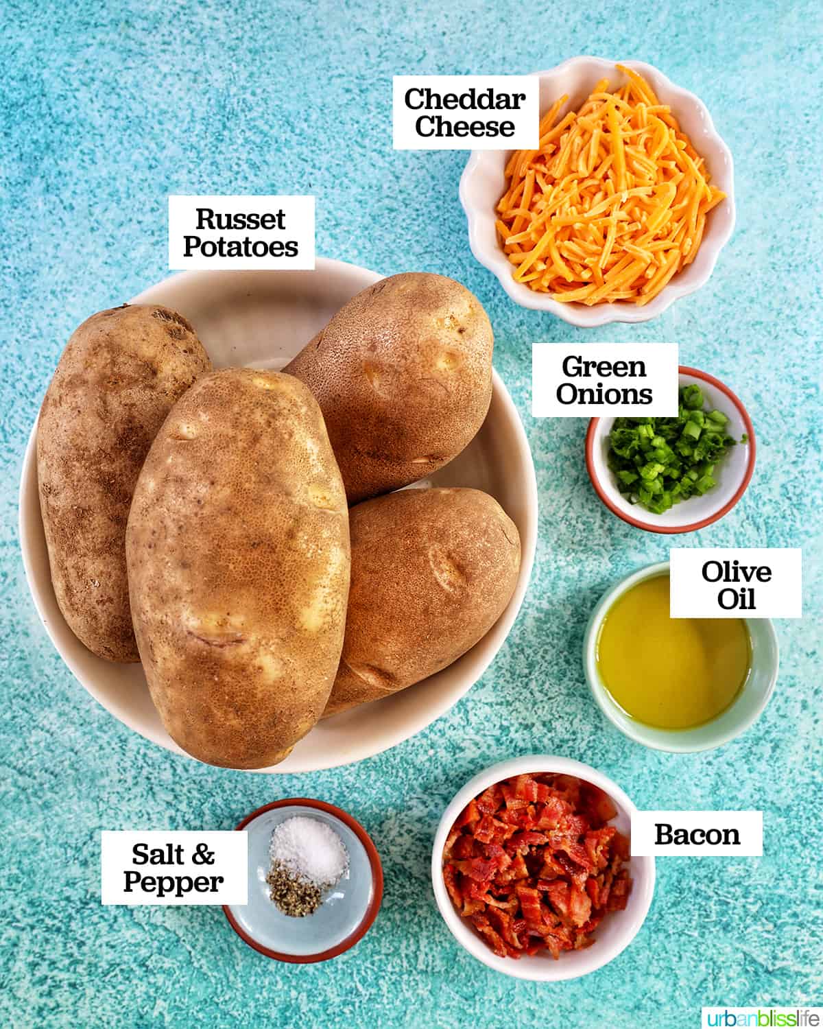 bowls full of individual ingredients to make Air Fryer Potato Skins on a blue background.