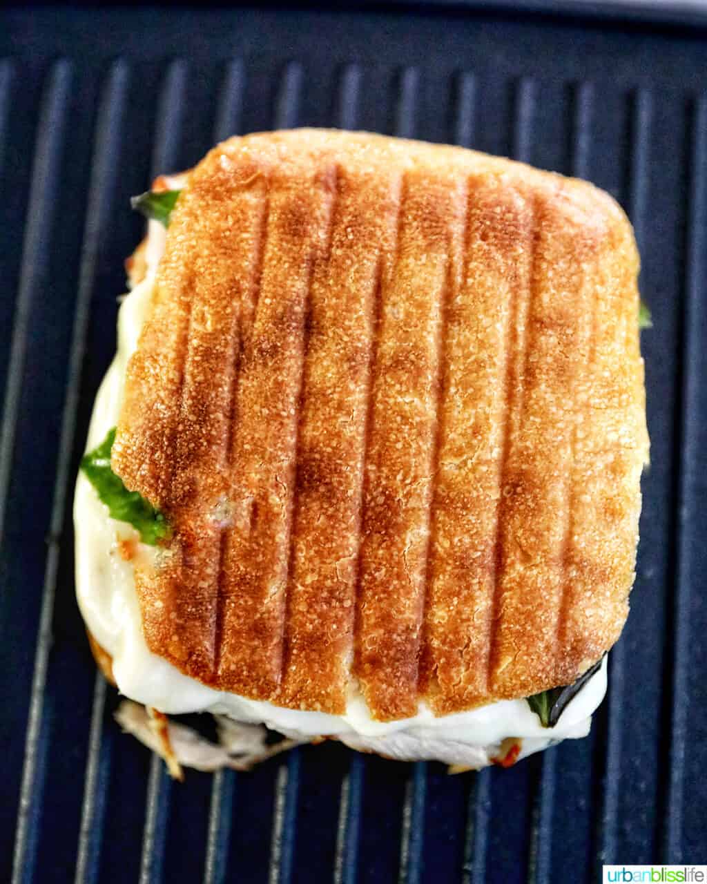 cooked turkey pesto sandwich on a panini press grill.