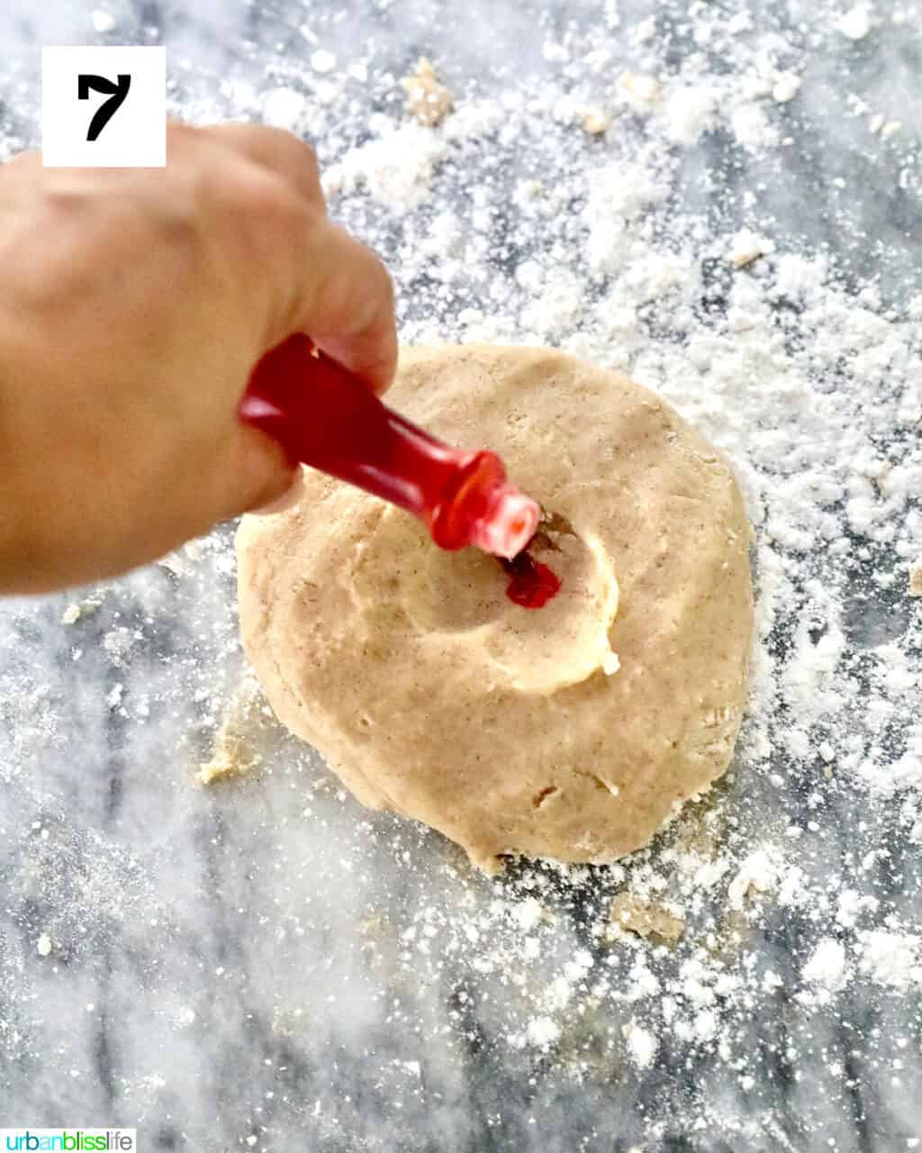 adding orange food coloring to cookie dough.