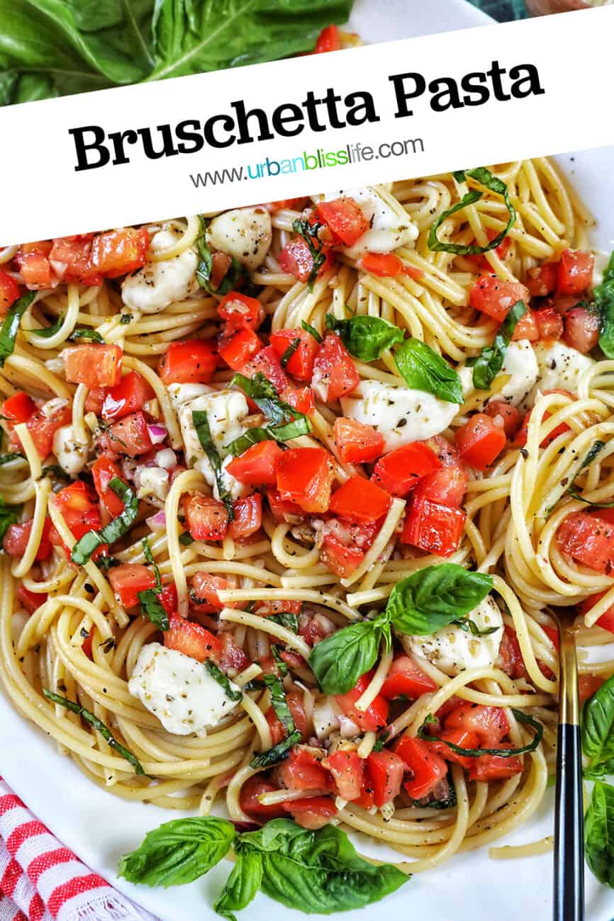 bruschetta pasta with tomatoes, basil, mozzarella cheese in a big white serving bowl with title text overlay.