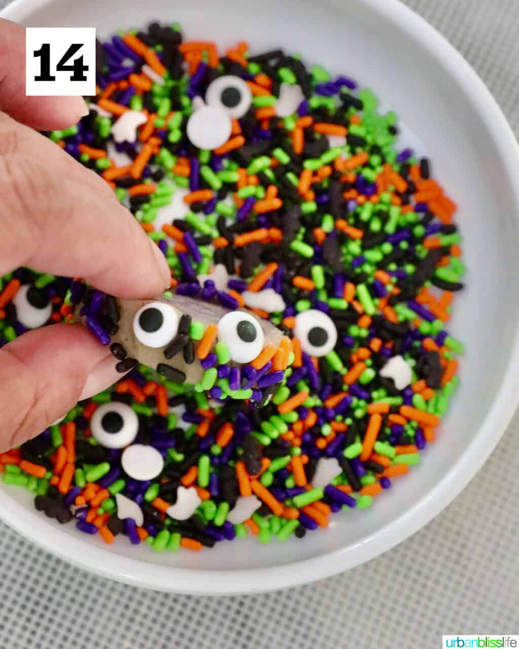 dipping sugar cookies into sprinkles