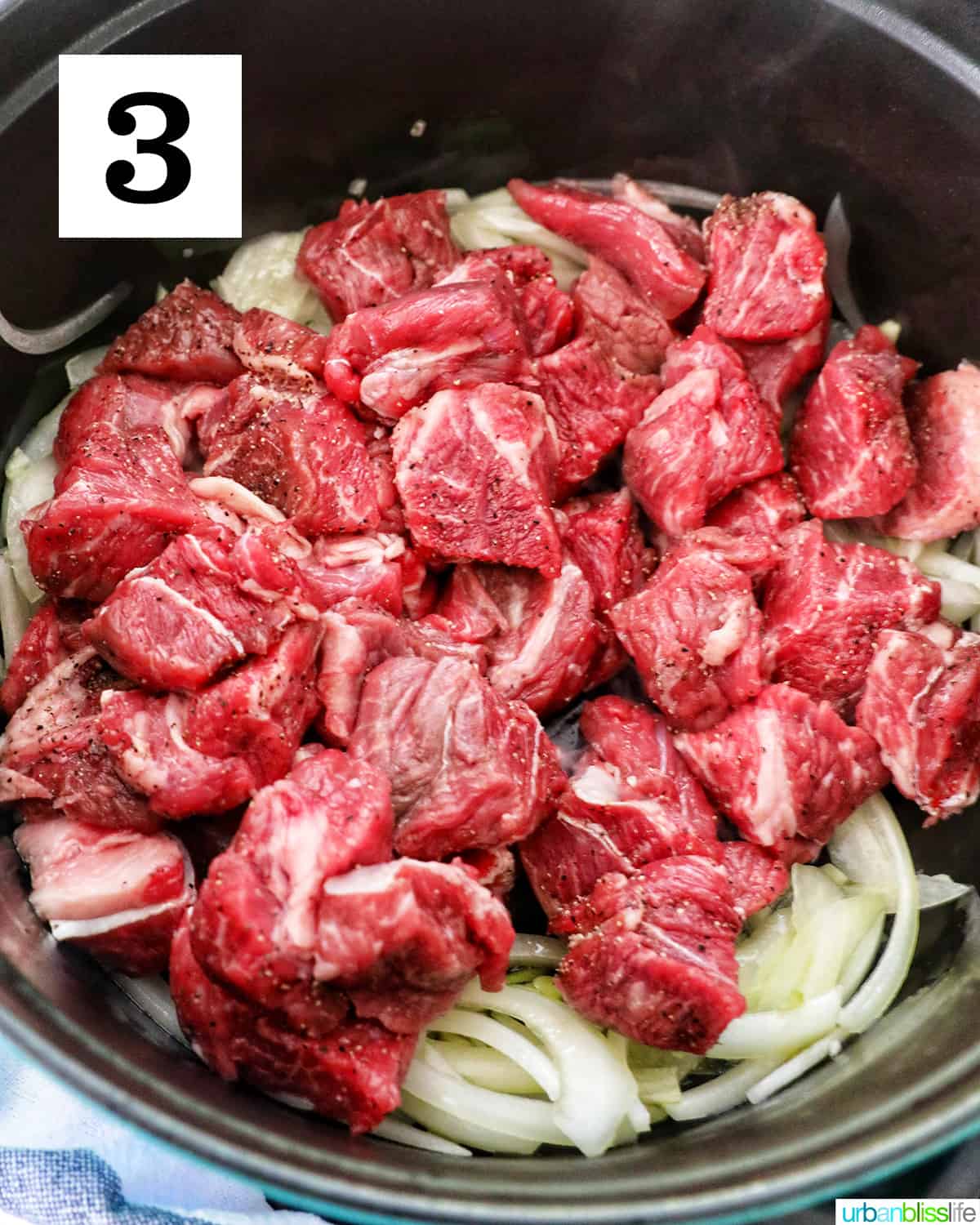 added beef chunks to cooked onions and garlic in a dutch oven.