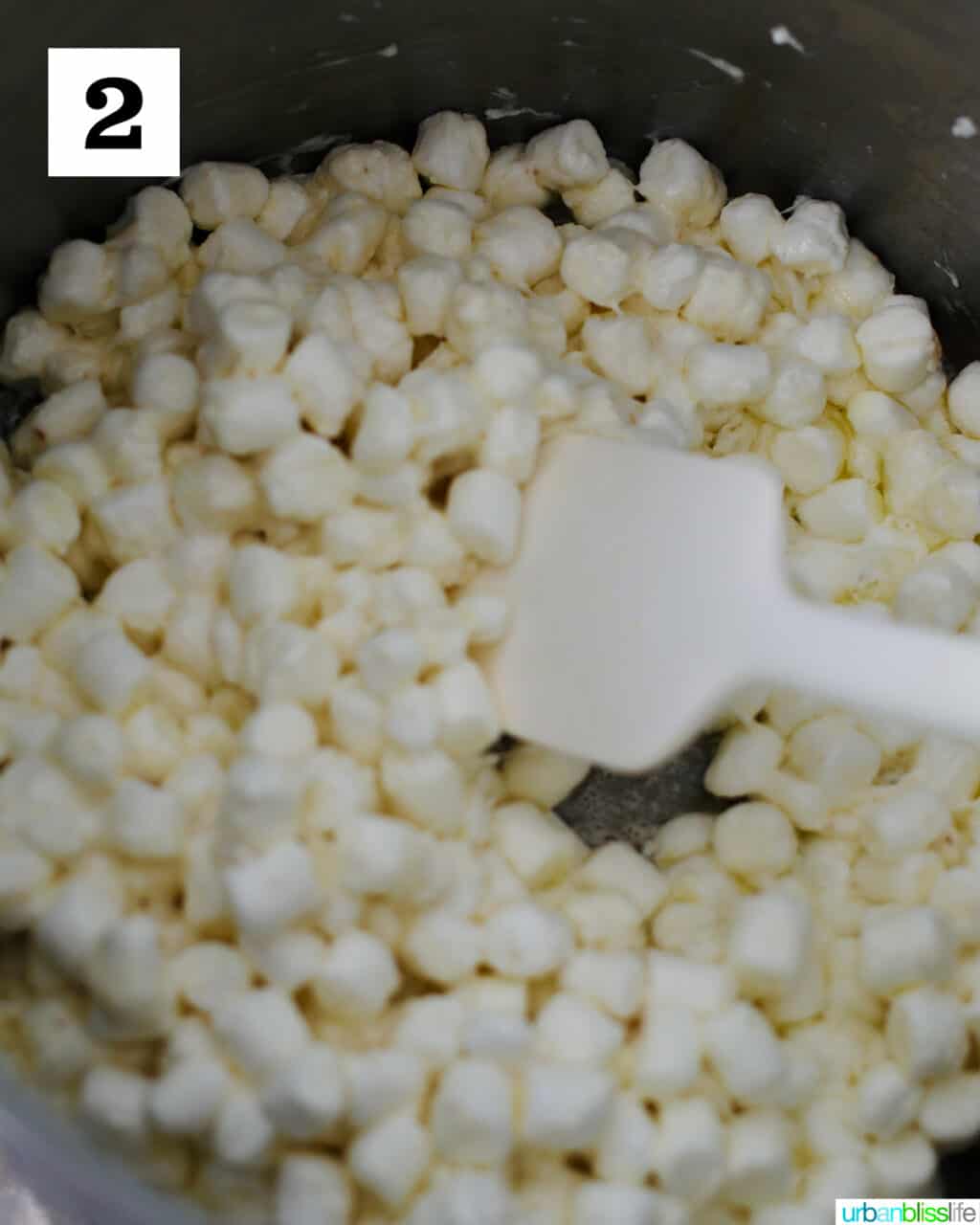 adding butter with marshmallows in pot