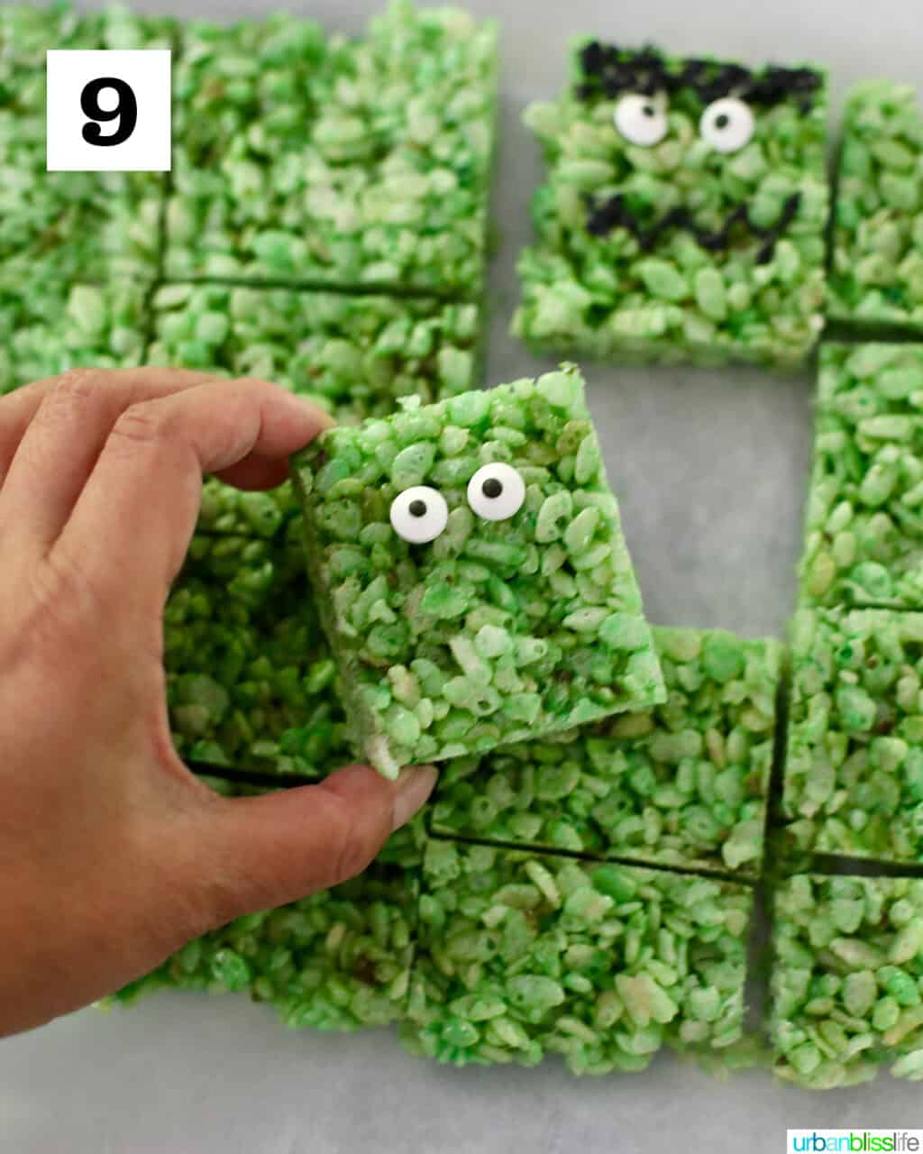 adding googly eyes to green rice krispies