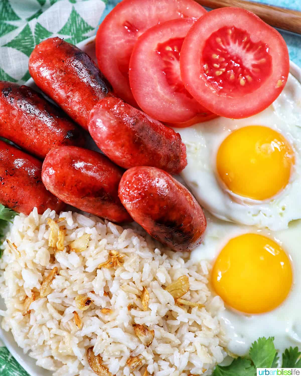 longanisa sausage, sliced tomatoes, fried eggs, and garlic rice known as Filipino Longsilog.