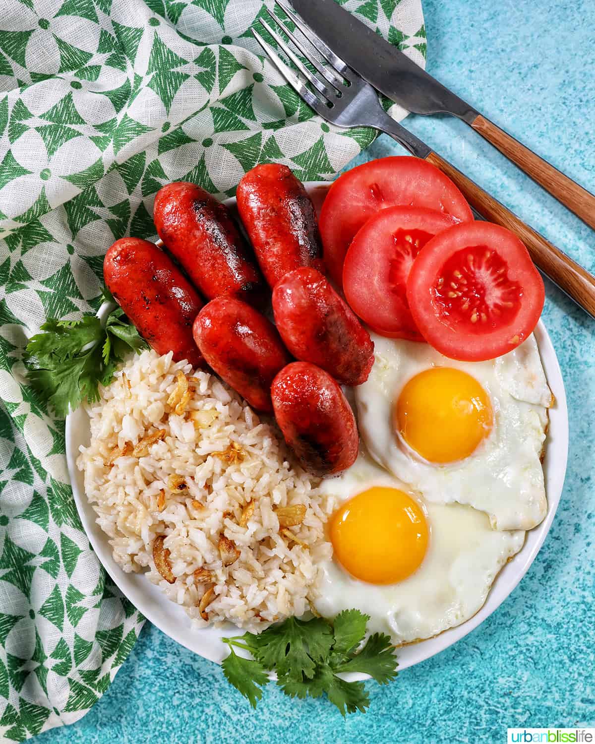 longanisa sausage, sliced tomatoes, fried eggs, and garlic rice known as Filipino Longsilog.