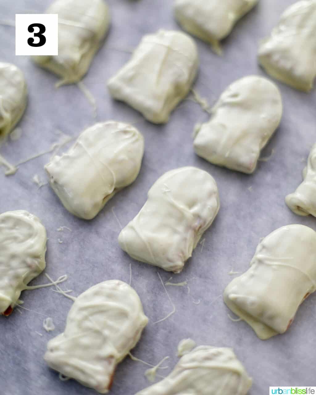 Nutter Butter cookies dipped in white chocolate on baking sheet.