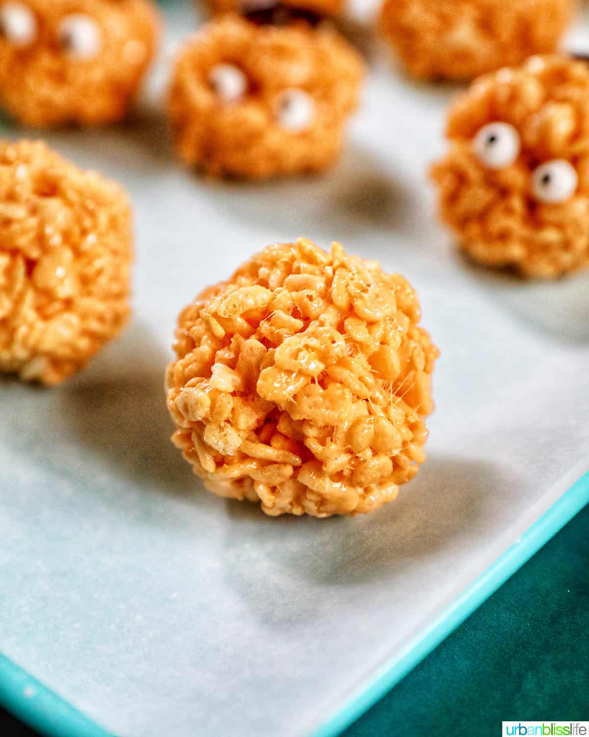 orange pumpkin rice krispie treats on parchment paper.