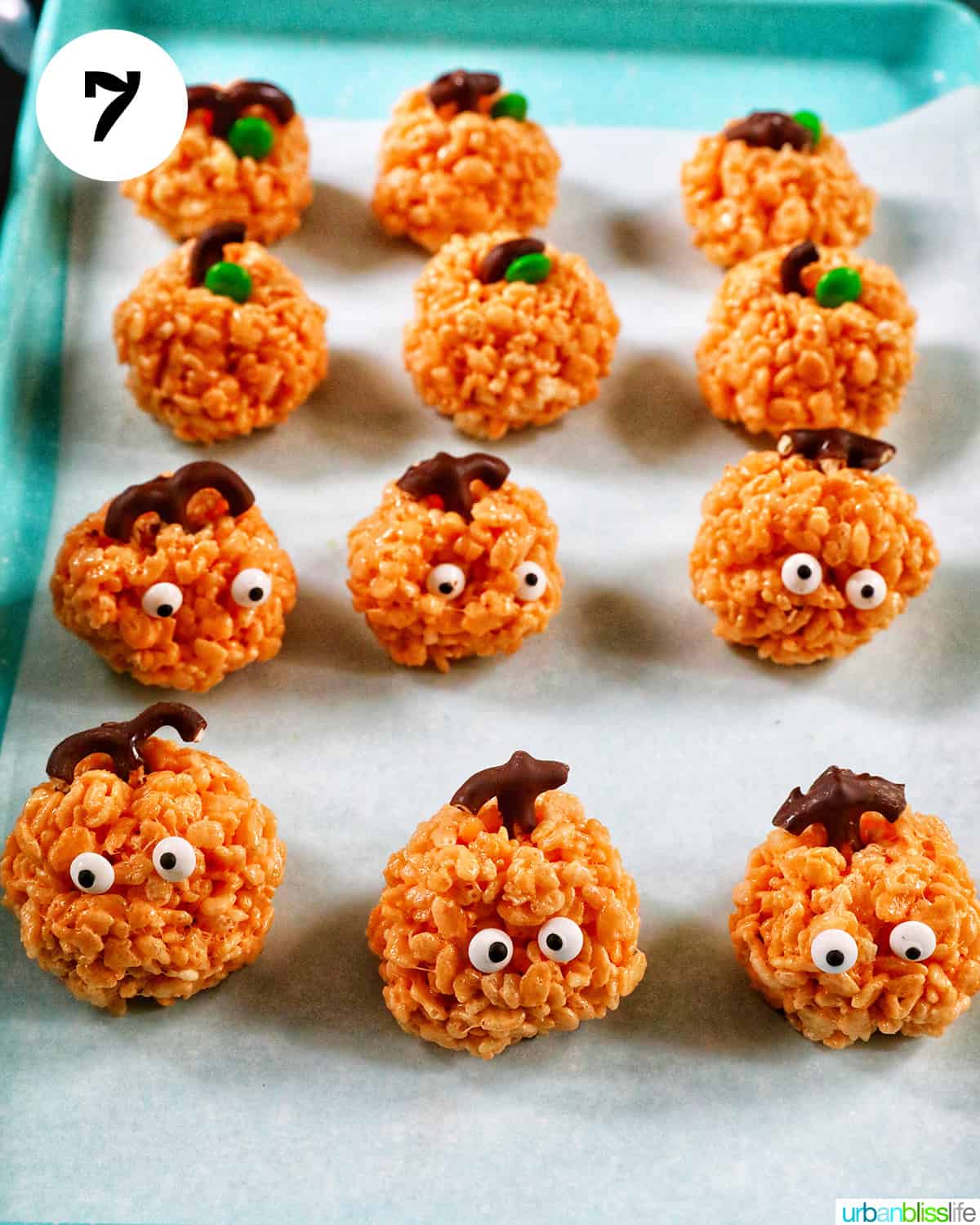 orange pumpkin rice krispie treats on parchment paper.